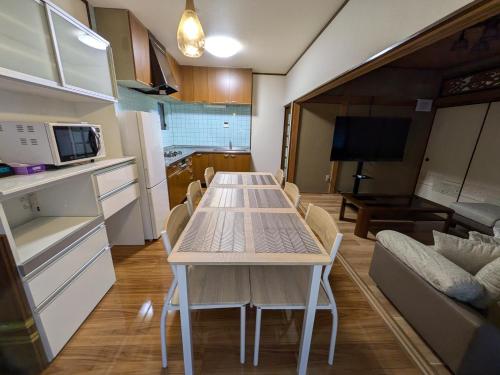 a kitchen and living room with a table and a couch at Villa Ishiyamadera ヴィラ 石山寺 in Otsu