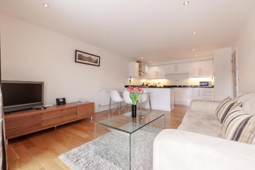 a living room with a white couch and a table at Roomspace Serviced Apartments - Marquis Court in Epsom