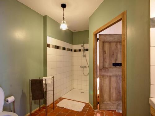 a bathroom with a shower with a wooden door at Gîte de charme avec spa, sauna et jardin pour 12 personnes - FR-1-496-54 in Saint-Just-la-Pendue