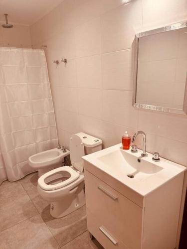 a white bathroom with a toilet and a sink at Center Suites Ideal parejas in La Plata