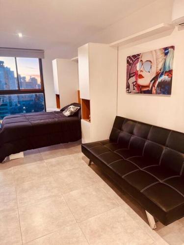 a living room with a bed and a couch at Center Suites Ideal parejas in La Plata