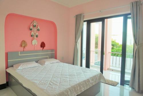 a bedroom with a large bed and a large window at Pink Sea Villa in Cu Lao Thu