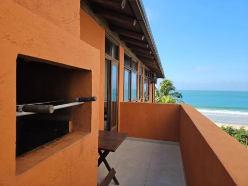 a building with a balcony with a view of the beach at Pousada Pedra da Gaivota in Bombinhas