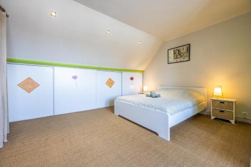 une chambre avec un lit blanc dans une pièce dans l'établissement Duplex hypercentre, à Dinard