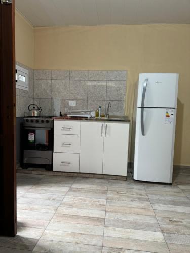 a kitchen with a white refrigerator and a stove at Residencia Las Americas in Garupá