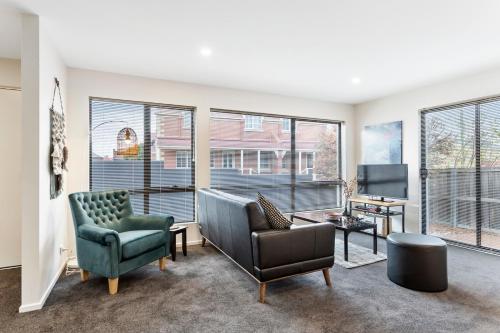 a living room with two chairs and a television at Four on Flinders - one bedroom apartment in Sandy Bay