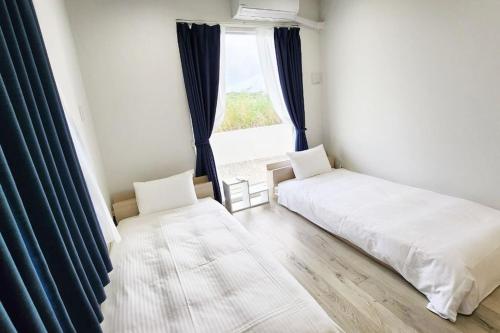 een slaapkamer met twee bedden en een raam bij vebora shine in Bora