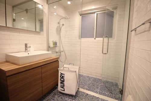 een badkamer met een douche, een wastafel en een glazen douchecabine bij vebora shine in Bora