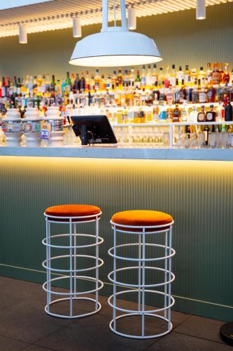 two bar stools with orange tops sitting at a counter at Cottesloe Beach Hotel in Perth