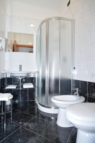 a bathroom with a shower and a toilet and a sink at Hotel La Cantina in Alfonsine