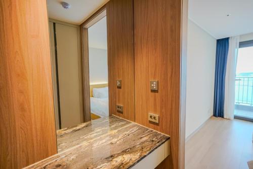 a hotel room with a large mirror and a bedroom at More than Sokcho in Sokcho
