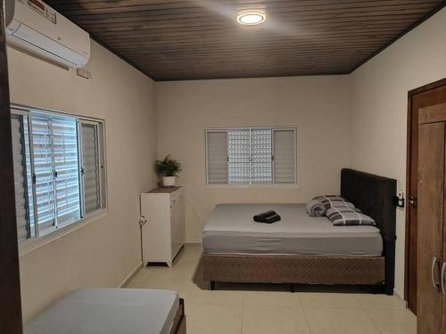 a bedroom with a bed and two windows at Sitio Kayal - A Paz no Vale do Paraiba in Aparecida