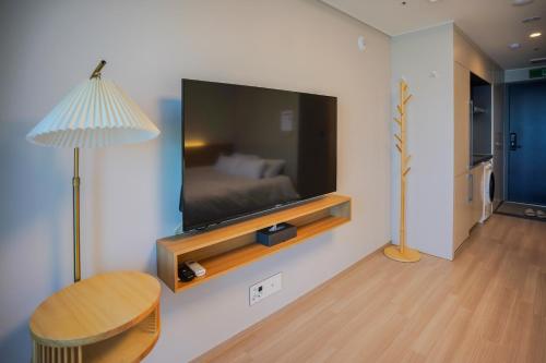 a living room with a flat screen tv on a wall at More than Sokcho in Sokcho