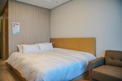 a bedroom with a large bed and a couch at More than Sokcho in Sokcho