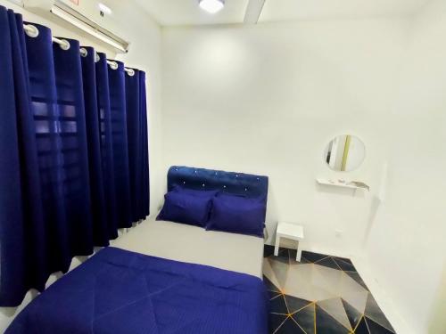 a room with a bed with blue pillows and a mirror at FIRASH HOMESTAY AT SERI ISKANDAR in Seri Iskandar