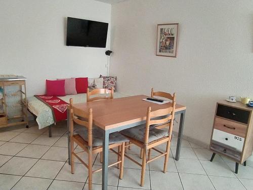 - une table à manger avec 4 chaises et un canapé dans l'établissement Appartement 2P 4 Pers, à 500m Plage, Parking, WIFI, Petits Animaux OK - FR-1-776-107, à Argelès-sur-Mer