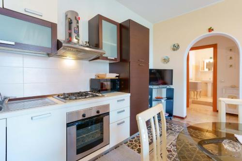 a kitchen with a stove top oven next to a table at Guest House Baruffi in Carloforte