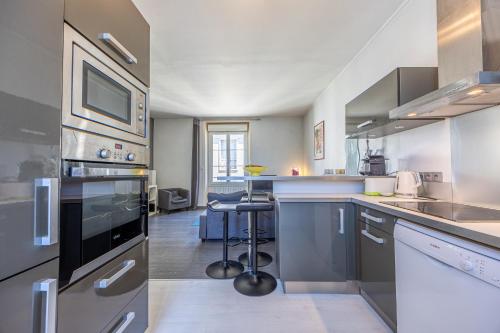une cuisine avec des appareils en acier inoxydable et un salon dans l'établissement Duplex hypercentre, à Dinard