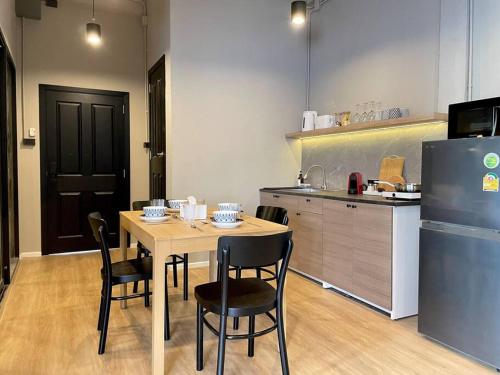a kitchen with a table and chairs and a refrigerator at Vélin Khaosan - 5th Floor apartment with 2Bedrooms in Bangkok