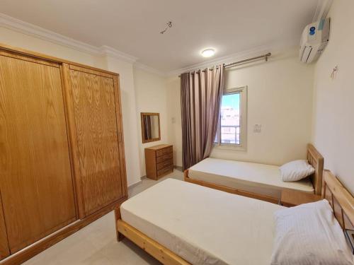 a bedroom with two beds and a window at Star house apartments in Hurghada