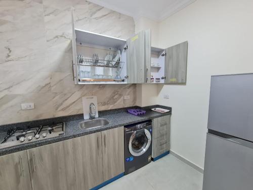 a kitchen with a sink and a washing machine at Star house apartments in Hurghada