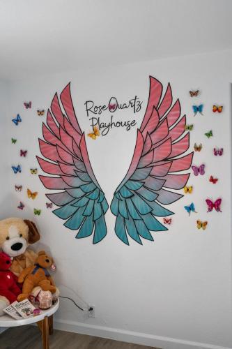 a bedroom with a wall with a mural of wings at Rosequartzplayhouse Wgmrm&more! in Sedona