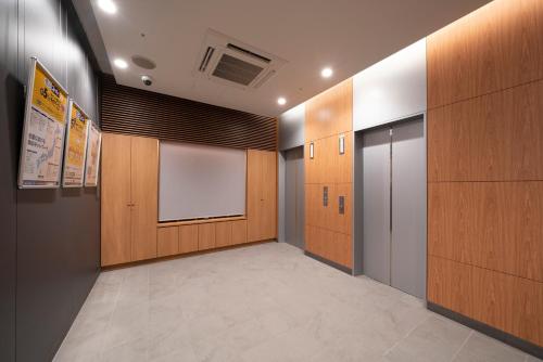 a hallway with wooden doors and a window at washingtonR&B Hotel Sendai Higashiguchi in Sendai