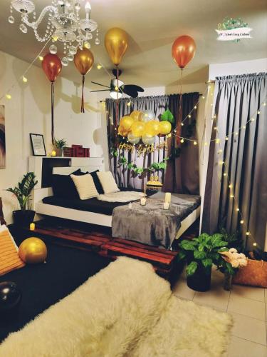 a bedroom with a bed and a chandelier with balloons at El Nissi Staycation, FAMILY CABIN, CONTEMPORARY CABIN, Enchanted Kingdom in Santa Rosa