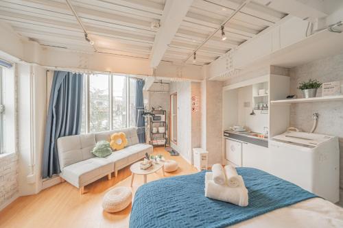 a room with a bed and a couch and a kitchen at Blue Sky Home Osaka Kishinosato Close to Station in Osaka
