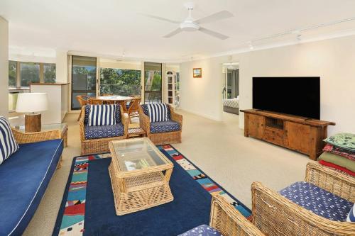 a living room with wicker furniture and a flat screen tv at Spinnaker Quays in Mooloolaba