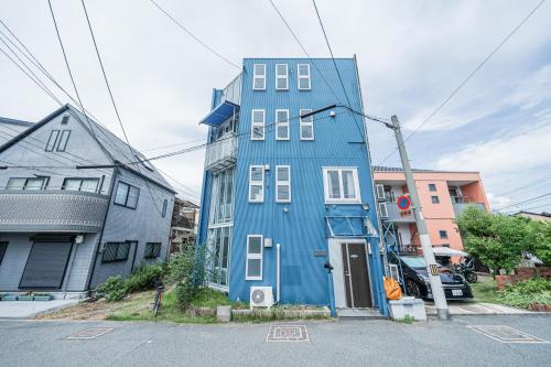 a blue building in the middle of a street at Blue Sky Home Osaka Kishinosato Close to Station in Osaka