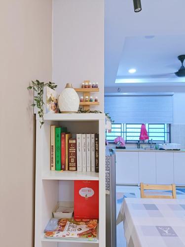 a book shelf filled with books next to a table at Zen Clan Homestay Scientex with wifi, aircond, water heater in Pasir Gudang