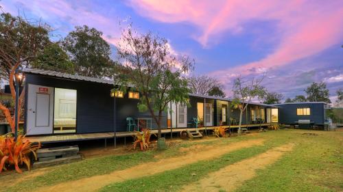 a house in the middle of a yard at Silver Wattle Cabins in Mount Morgan