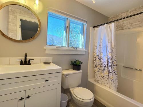 un bagno con lavandino, WC e specchio di FirBear- AC, Pool, Hot Tub, Sauna, Tennis, Gym a Killington