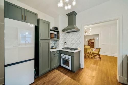 a kitchen with green cabinets and a stove top oven at Walk to Cherry Street,pets, hot tub by HVNLYhomes in Tulsa