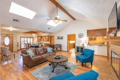 a living room with a couch and a table at Beautiful Texas Ranch House, Game Room & Minigolf in San Antonio