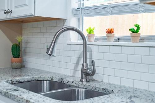 a kitchen counter with a sink and a window at Texas Vacation Home, Game Room & Pool By Sixflags in San Antonio