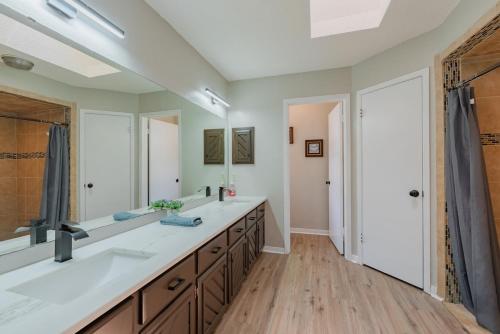 a bathroom with two sinks and a large mirror at Beautiful Texas Ranch House, Game Room & Minigolf in San Antonio