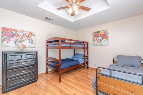a bedroom with two bunk beds and a ceiling fan at Beautiful Texas Ranch House, Game Room & Minigolf in San Antonio