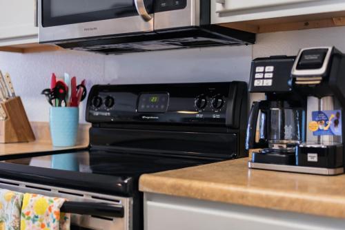 a kitchen with a black stove and a microwave at Luxury 6br Home, Game Room By Lackland & Seaworld in San Antonio