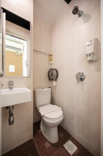 a bathroom with a white toilet and a sink at Fragrance Hotel - Rose in Singapore