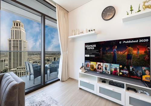 a living room with a large flat screen tv at Palace Residences 2BR with Stunning Creek Views in Dubai