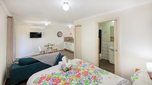 a living room with a bed and a blue couch at Silver Wattle Cabins in Mount Morgan