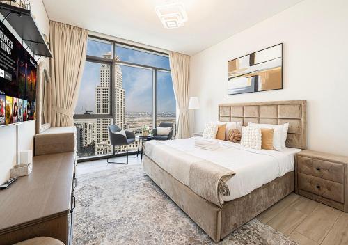 a bedroom with a large bed and a large window at Palace Residences 2BR with Stunning Creek Views in Dubai