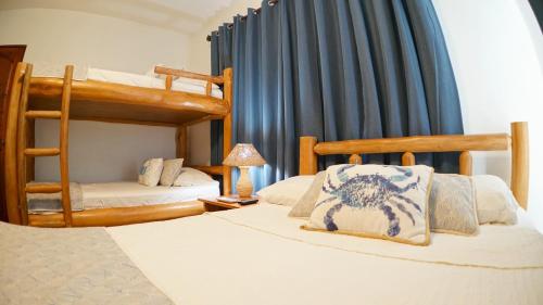 a bedroom with two bunk beds and a lamp at Villas Welcome to Heaven in Carrillo
