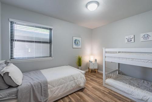 a white bedroom with a bunk bed and a window at Stunning Pool Overlooking Golf Course & Game Room in San Antonio
