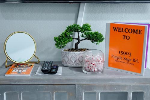 a bonsai tree sitting on a shelf next to a mirror at Breathtaking Roof Pool Views, Gameroom, Firepit in San Antonio