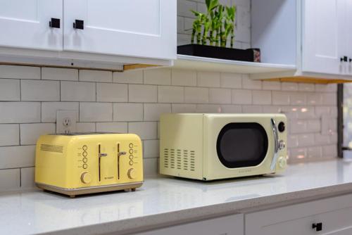 a microwave sitting on top of a kitchen counter at Breathtaking Roof Pool Views, Gameroom, Firepit in San Antonio