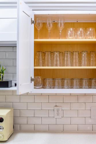 a kitchen cupboard with wine glasses in it at Breathtaking Roof Pool Views, Gameroom, Firepit in San Antonio