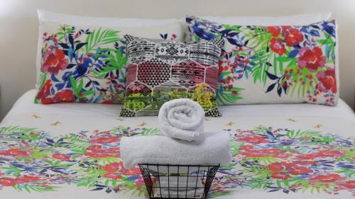 a bed with a pile of towels and pillows at Silver Wattle Cabins in Mount Morgan